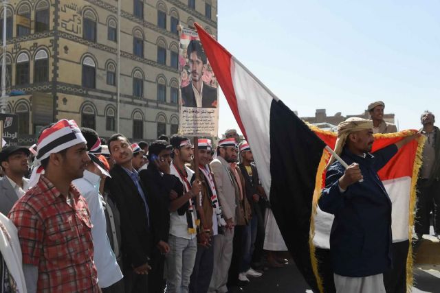 يمنيون يرفعون علم بلادهم