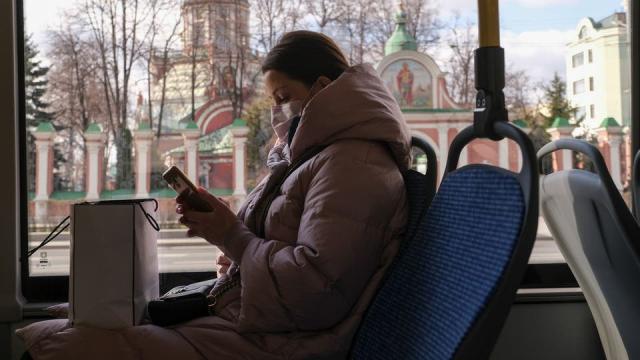 امرأة تضع كمامة على وجهها لدى ركوبها حافلة في العاصمة الروسية موسكو يوم 23 مارس (رويترز)