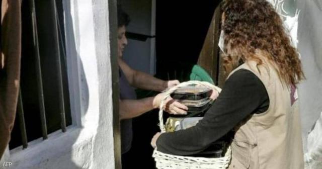 متطوعة تحمل وجبة طعام إلى عائلة في بيروت